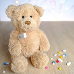close-up of many colored pills, medicine, capsules, teddy bear kids toy with stick thermometer, concept of pediatrics, childhood diseases, treatment ,selective focus at a shallow depth of field