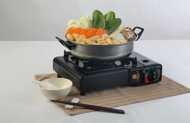 Black portable tourist gas stove with sukiyaki pot