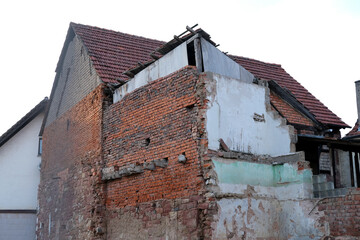 ruined house with empty windows, broken brick, cracks on the wall of a dilapidated building, the concept of ruin of people, business collapse due to Social problems, poverty, Low income, Urban decay