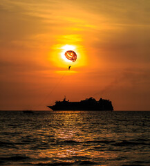 sunset on the beach with cruise ship in the background