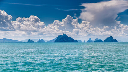 view of the island ridge from the sea with blue sky and clouds
