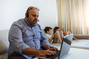 Millennial generation father working from home with small children while in quarantine isolation...