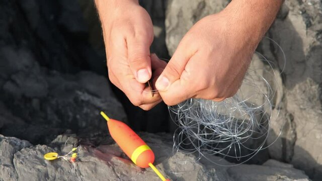 tangled fishing line, man attaches lead to tangled fishing line