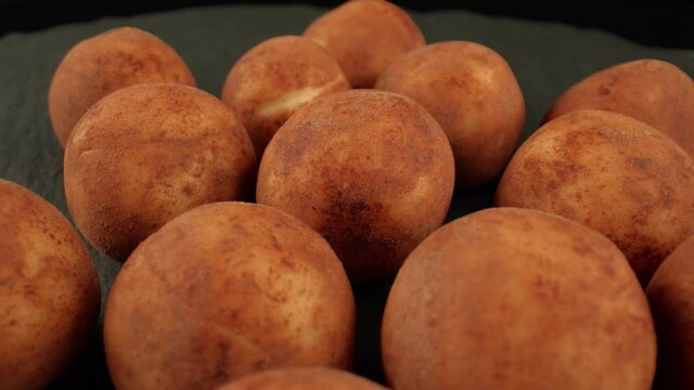 A few delicious marzipan in the dark background. Products for confectionery stores. Marzipan potatoes. High content of almonds and sugar in the product. High quality. 4k footage.