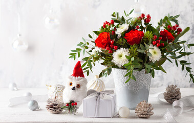 Fototapeta na wymiar Christmas or New Year flowers arrangement and festive decorations on table. 
