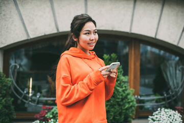 Asian woman with smartphone on street