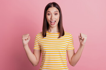 Photo of cheerful astonished lady raise fists open mouth celebrate victory on pink background