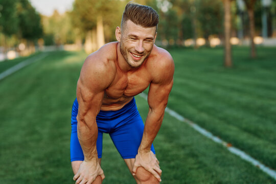 sporty man with pumped up body in park workout exercise