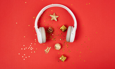 Christmas Music or podcast background. Golden christmas decorations and white headphones on red...