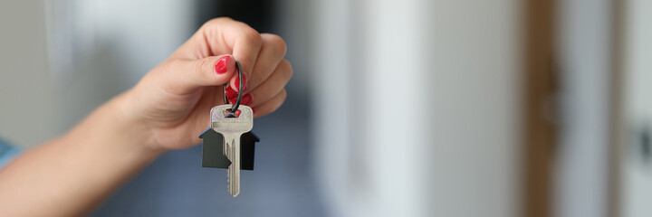 Female hand holds key to apartment closeup