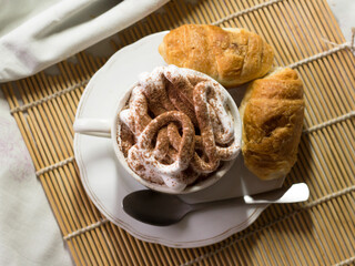 A cup of cappuccino and delicious croissants
