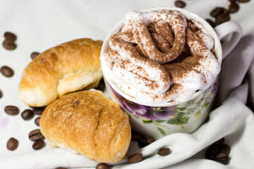 A cup of cappuccino and delicious croissants