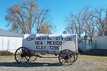A sign for the Continental Divide in New Mexico is placed on an old-style covered wagon.