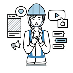 立ってスマートフォンでさまざまなSNSで楽しく交流する工事現場の女性
