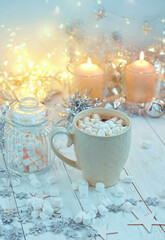 Coffee cup with marshmallow, Christmas decor and candles on table. Christmas and new year holiday concept. winter festive seasonal composition. 