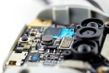 Macro pictures of an integrated circuit on a black PCB, visible optical sensors and semiconductors.