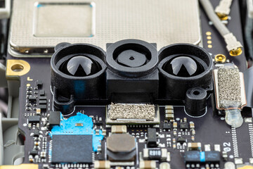 Macro pictures of an integrated circuit on a black PCB, visible optical sensors and semiconductors.