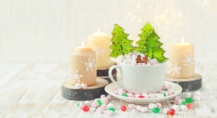 Cup with Christmas sweets, marshmallow, candles on table. Christmas and new year holiday concept. winter festive season. copy space