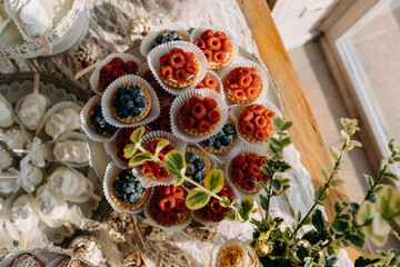 Candy bar table setting with different sweets at a restaurant. Tarts with berries.