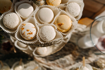 Closeup of different white and beige macaroons on a candy bar at a cafe.