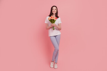 Fototapeta na wymiar Photo of charming lovely cheerful girlfriend hands hold bunch tulips isolated pink color background