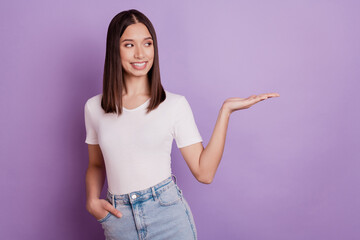 Photo of young cheerful girl happy positive smile hold hand product promo offer advert isolated over violet color background