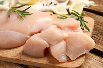 Fresh raw cut chicken breast with rosemary on wooden table, closeup © New Africa
