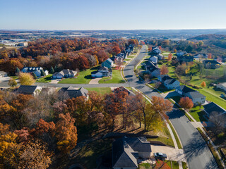 Aerial view of Eau Claire, Wisconsin, residential neighborhood in autumn.  Wide streets with curbs and sidewalks. Large homes and yards.  Park nearby.