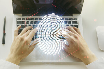Multi exposure of abstract fingerprint scan interface with hands typing on computer keyboard on background, digital access concept