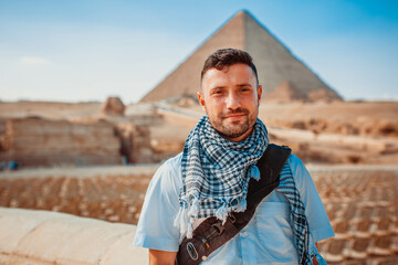 Young man tourists taking pictures in front of the pyramids of Giza in Cairo, the capital of Egypt