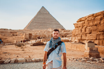 Young man tourists taking pictures in front of the pyramids of Giza in Cairo, the capital of Egypt