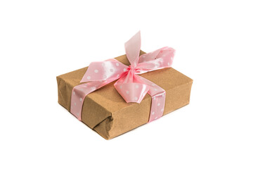 Gift wrapped in brown paper and tied with a pink ribbon on a white background. Isolated