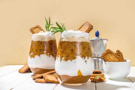 Biscoff coffee latte with cookie pasta, whole cookies, whipped cream and rosemary decor 