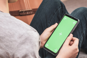 boy holding the smartphone with green screen