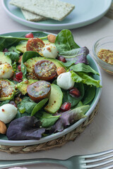 Green leafy salad with avocado, pomegranate, mozzarella balls, cherry tomatoes and almonds. Healthy food. Homemade food