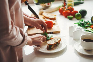 Close-up portrait of couple hands preparing healthy meal in the kitchen together. Healthy sandweach. Vegetarian