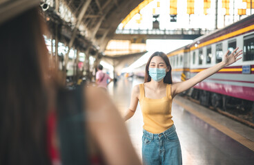 Woman traveler with bag, luggage, arrival   during traveling, travel, trip for woman concept, say hi, good bye to friend.trip in summer with face mask for protection by infection from Coronavirus.