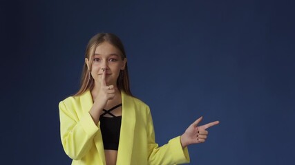 The girl gestures for silence with a finger to her lips