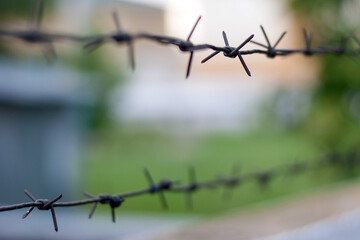 Barbed wire on the fence in the city. Territory security.