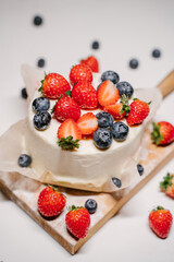 small strawberry bento cake. garnished with strawberries and blueberries