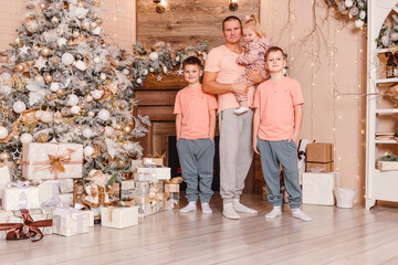 happy father and three children near the Christmas tree. the same clothes. family photo shoot