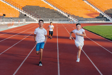 A large group of boys ' children are taught by a coach at the start before running at the stadium...