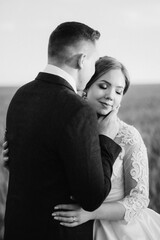 the groom and the bride walk along the wheat green field