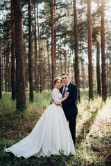 the bride and groom are walking in a pine forest