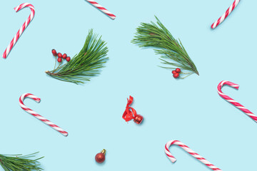 Christmas inspired beautiful pattern. Pattern made of red and white candy canes, pine trees , red berries, little decoration on pastel blue pink