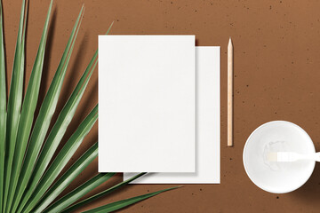 Clean minimal A5 flyer mockup on top marble background with leaves and white plate