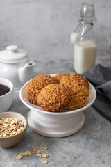 Delicious homemade oat cookies with a cup of coffee, healthy sweet snack, bright background.