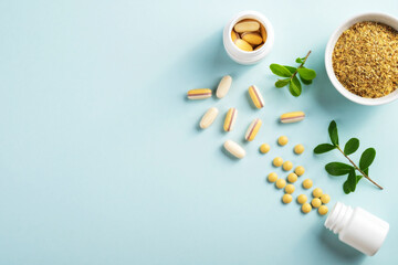 Vitamins and herbal supplements in jars with a green plant on a blue background..Biologically active additives. Dietary supplements.