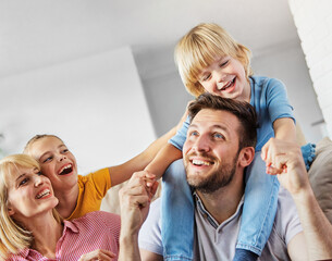 child daughter son family happy mother father sofa playing fun together girl boy cheerful smiling home together