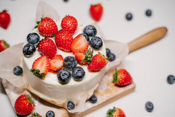 small strawberry bento cake. garnished with strawberries and blueberries
